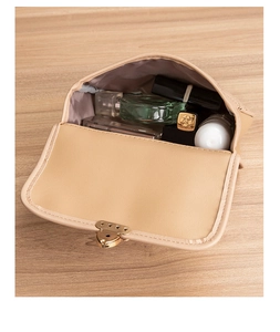 Close-up of beige quilted makeup bag featuring a golden heart-shaped twist lock buckle