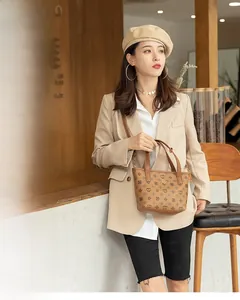 Detail view of the vintage floral pattern and leather handles on the brown bucket bag