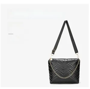 Detail of wave quilted bucket bag with V-shaped stitching and gold chain strap