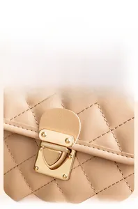 Detail of beige quilted leather handbag featuring a polished gold buckle and fine stitching