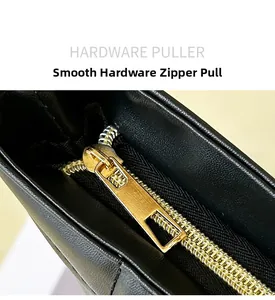 Close-up of smooth gold hardware zipper puller on a black quilted tote bag detail