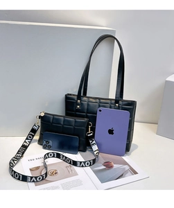 Détail d'un sac cabas noir matelassé et bandoulière avec inscription LOVE sur sangle