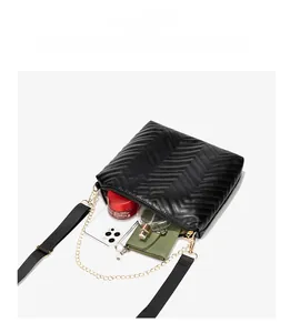 Detail of wave quilted crossbody bag showing large capacity with phone and cosmetics