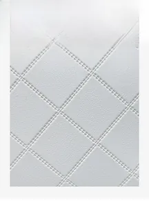 Close-up of premium white quilted leather with elegant diamond stitching and glossy finish