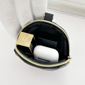 Chic black leather bucket bag with gold zipper and interior storage for cosmetics