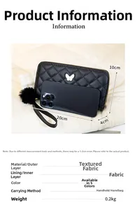 Détail du portefeuille matelassé noir avec logo papillon et breloque pompon doux