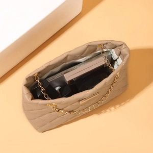 Quilted beige bucket bag with gold chain showing daily essentials and large capacity