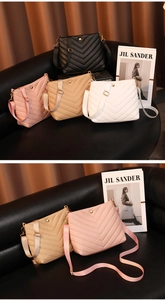 Detail of V-quilted bucket bags with adjustable straps and gold metal hardware
