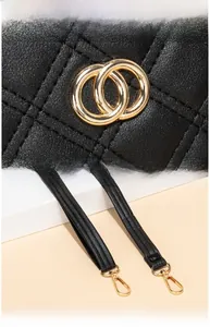 Detail of black quilted leather handbag with gold double-ring hardware and detachable strap