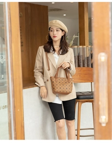 Close-up of heart pattern brown handbag with leather handle and adjustable strap