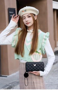 Pochette matelassée noire avec papillon métallique et dragonne à pompon en fourrure
