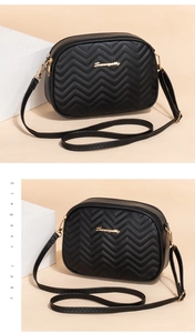 Detailed view of black V-quilted camera bag with gold logo and elegant hardware