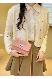 Close-up of pink quilted crossbody bag with gold-tone twist lock and thin shoulder strap