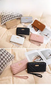 Detailed view of long double-zipper wallet featuring V-quilted faux leather and hand strap