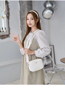 Détails du sac à bandoulière blanc avec motif tissé et fermoir papillon doré