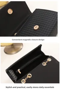 Detail of black woven crossbody bag featuring golden magnetic ring clasp and chain strap