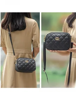 Detail of black quilted leather crossbody bag with gold ring buckle and adjustable strap
