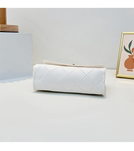 Detail view of ivory white rectangular handbag with classic quilted diamond pattern