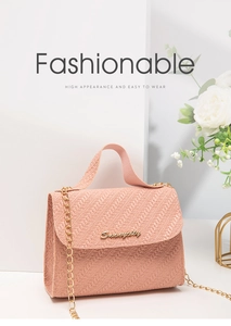 Détail du sac bandoulière rose avec texture matelassée en V, chaîne dorée et logo