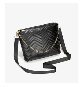 Close-up of wavy quilted pattern and gold chain detail on the black bucket bag