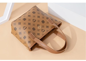 Detail of vintage monogram bucket bag showing gold clover logo and brown faux leather handle