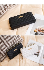 Close-up of long zip wallets with quilted texture and golden hardware in black and white
