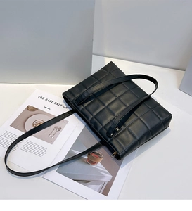 Détail d'un sac fourre-tout en cuir PU noir matelassé avec surpiqûres et zip métallique