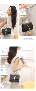 Detail of black woven leather crossbody bag with gold V-logo and fringe tassel pendant