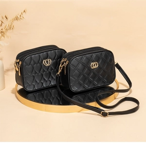 Detail of black PU leather cross-body bags with heart and diamond quilting patterns