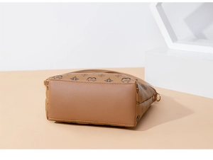 Detailed side view of a brown leather bucket bag showing patterned finish and gold hardware