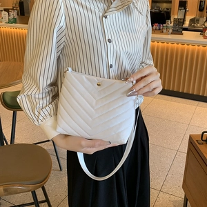 White chevron quilted leather bucket bag with gold buckle and adjustable shoulder strap