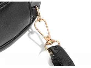 Detail of light gold hardware hook and wave embroidery on black litchi leather bag