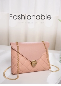 Detail of pink quilted shoulder bag featuring gold chain strap and metal lock closure
