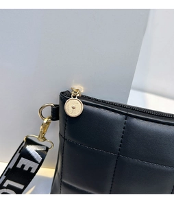 Détail du sac cabas matelassé noir avec finitions dorées et sangle à motif LOVE