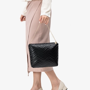 Classic black wave quilted bucket bag with gold chain strap shown from a side view