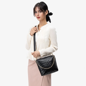 Quilted wave pattern crossbody bag with golden chain and black adjustable strap