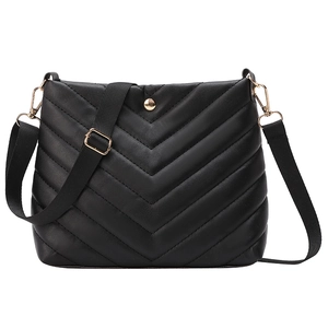 Modern black bucket bag with V-quilted stitching, wide strap, and golden metal hardware