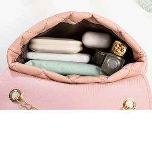 Detail showing the spacious interior of a quilted pink chain bag with daily essentials