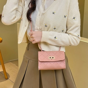 Pink quilted crossbody handbag with gold lock shown with model in stylish outfit