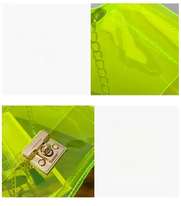 Detail of neon green transparent bag featuring polished gold hardware and chain strap