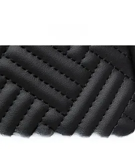 Détail macro du cuir matelassé noir avec une texture fine de points croisés