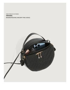 Detail of round woven crossbody bag showing interior capacity for phone and lipstick