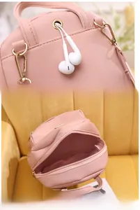 Dettaglio zaino in pelle PU rosa con foro per cuffie e cerniere metalliche dorate eleganti
