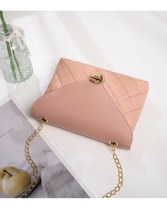 Detail of light pink quilted chain bag with gold twist lock on a lifestyle background