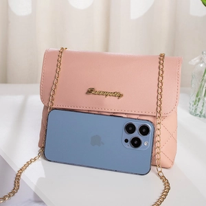 Pink quilted crossbody bag with gold chain strap shown next to a smartphone for size reference