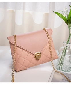 Detail of pink quilted crossbody bag featuring a golden twist lock and metal chain strap