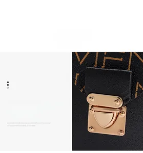 Détail du fermoir en métal doré sur sac en cuir noir avec imprimé monogramme chic