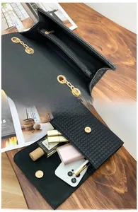 Internal view showing storage capacity and zipper pocket of black woven crossbody bag