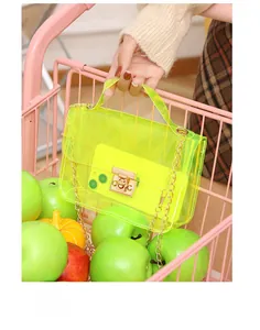 Detail of neon green transparent PVC bag with gold metal lock and chain in pink cart