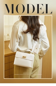 White crocodile pattern crossbody bag with mini pouch shown on a fashion model